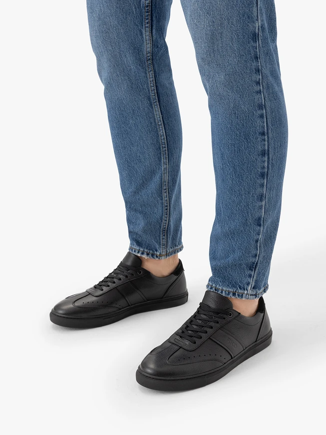 Schwarze sportliche Halbschuhe auf schwarzem Grund