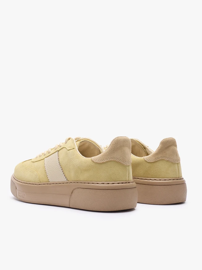 Leuchtend gelbe Turnschuhe aus Leder und Velours
