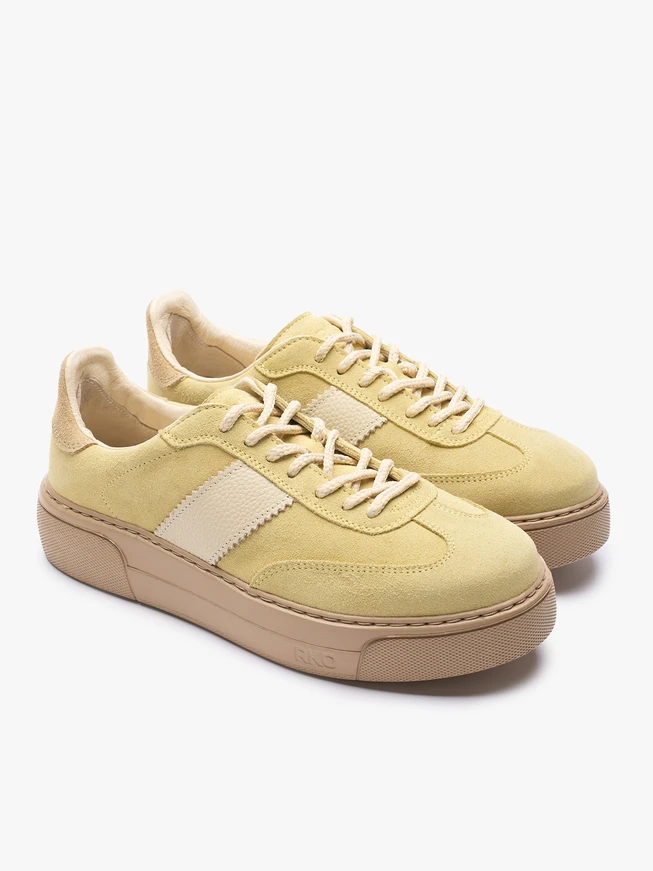 Leuchtend gelbe Turnschuhe aus Leder und Velours