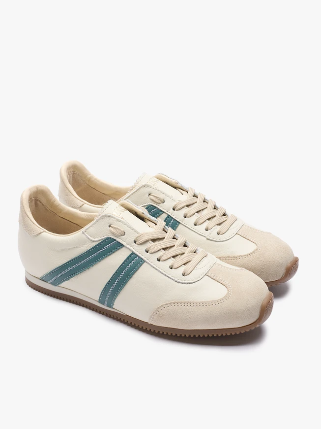 Cremefarbene Sporthalbschuhe mit türkisem Streifen