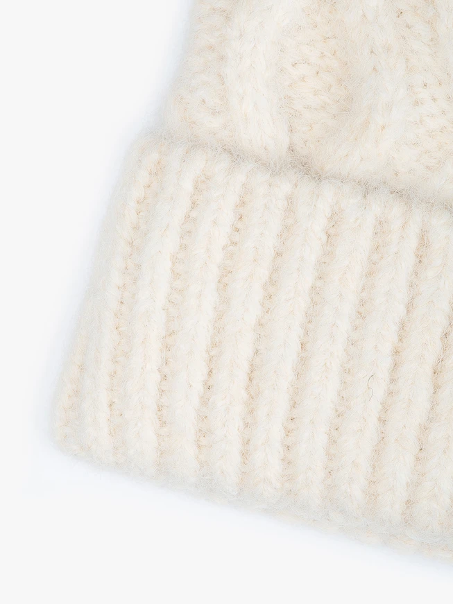 Cream-colored hat with a cable knit pattern