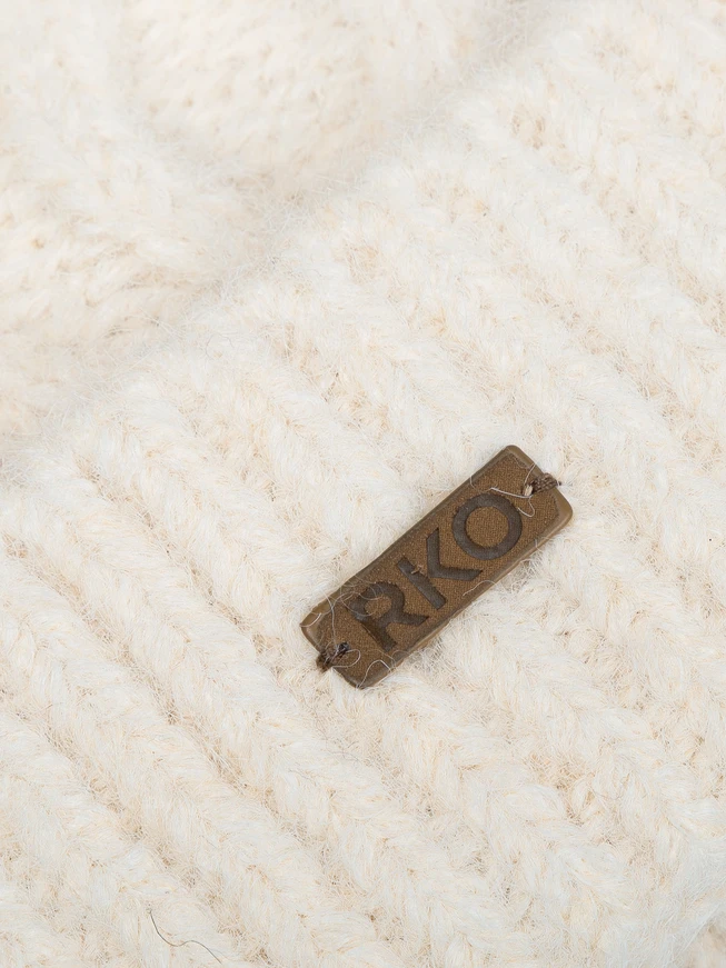 Cream-colored hat with a cable knit pattern